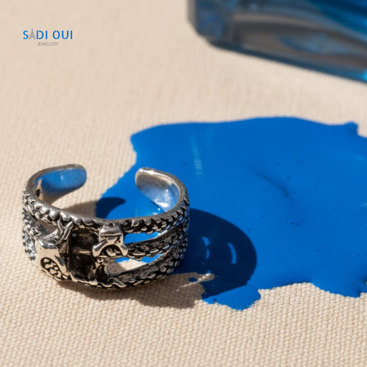 Anel 2 Serpentes Base em aço inoxidável prateado em fundo bege com detalhe de líquido azul
