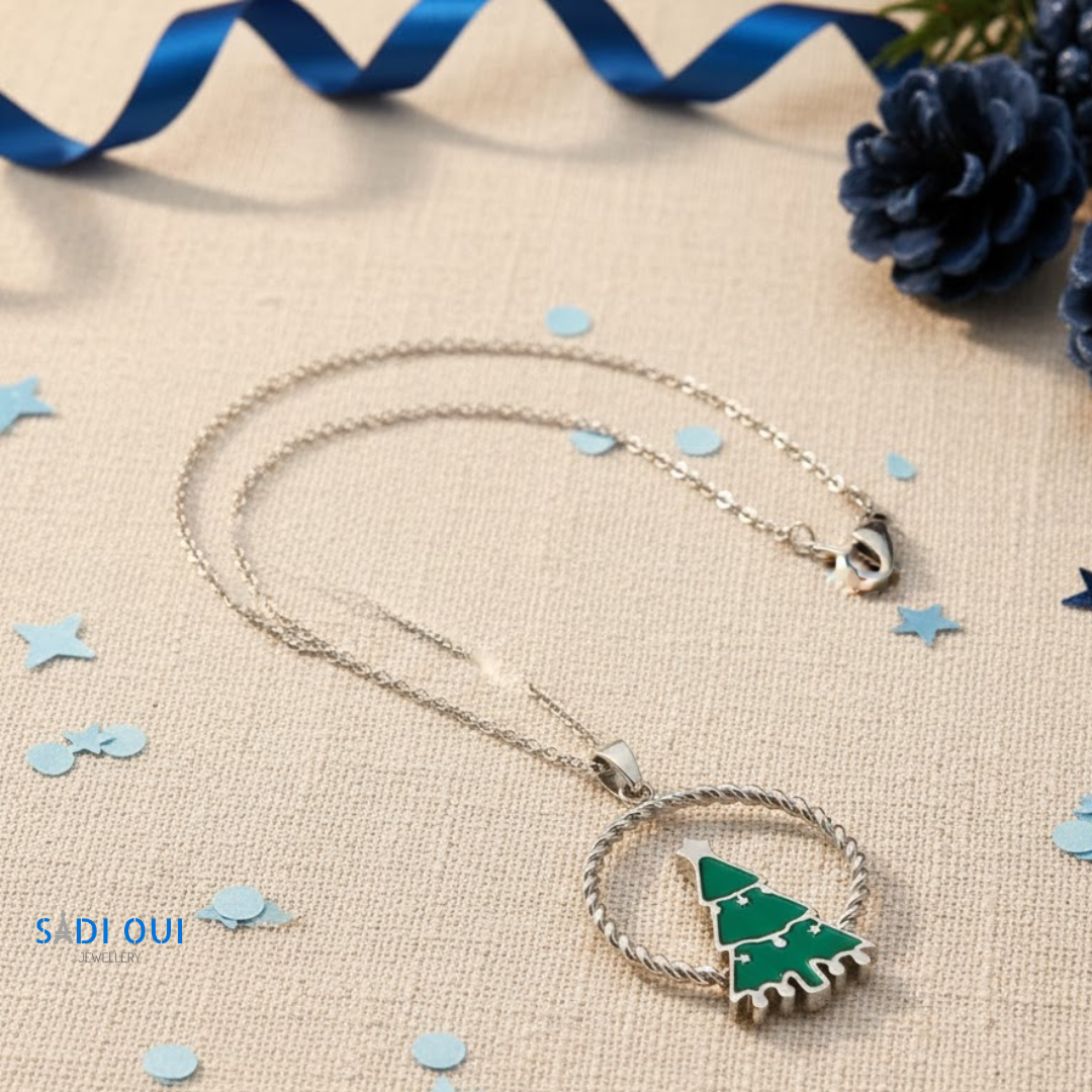 Colar Árvore de Natal Verde Christmas Fun prateado com pendente de árvore verde em fundo bege com confetis azuis
