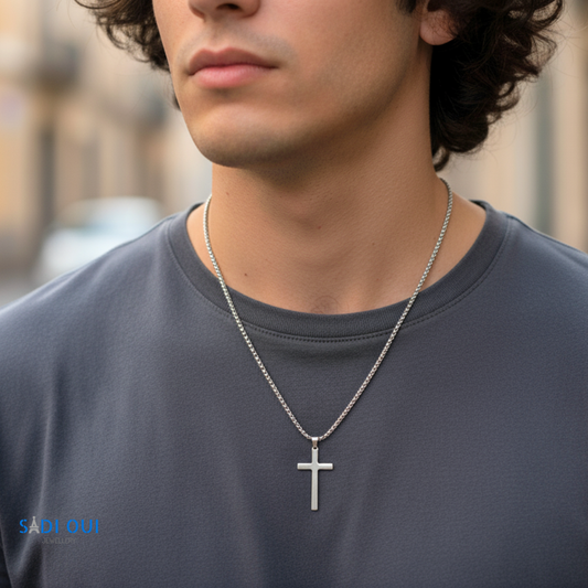 Colar Cruz Base em aço inoxidável prateado no pescoço de um modelo com t shirt cinzenta
