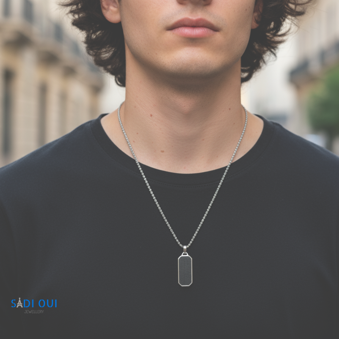 Colar Tag Base em aço inoxidável prateado no pescoço de um modelo com t shirt escura
