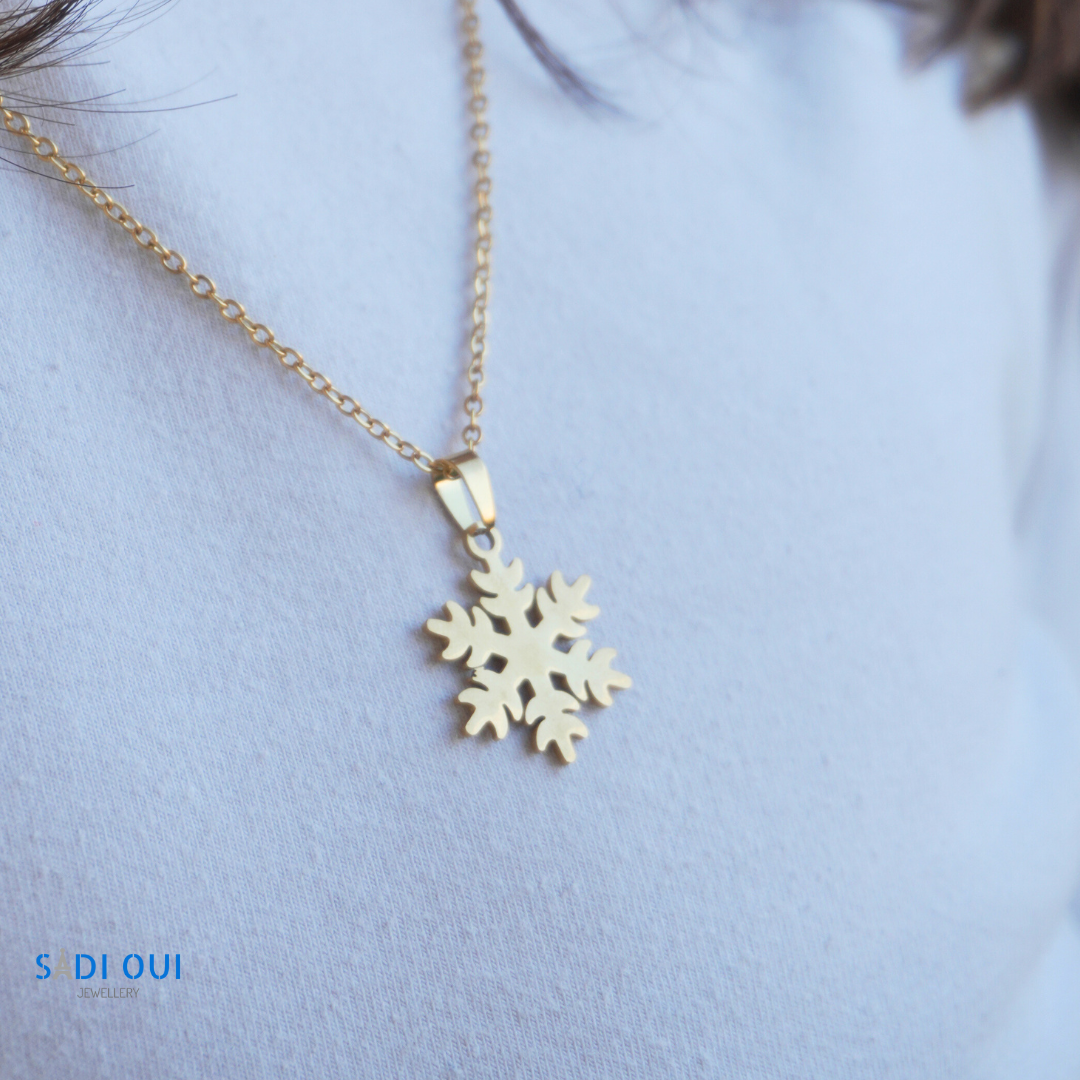 Colar dourado do Conjunto Floco de Neve Winter Magic em close up sobre t-shirt clara, joia de inverno SADI OUI Jewellery
