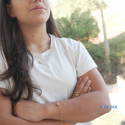 Pessoa a usar a Pulseira Pop Drop em aço inoxidável dourado com braços cruzados
